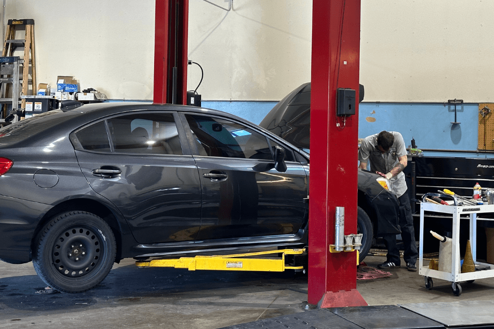 Car maintenance in Englewood, CO by Autovisions. Image of a technician working on a vehicle in a service bay, highlighting the shop’s dedication to precision repairs, safety, and keeping cars road-ready.