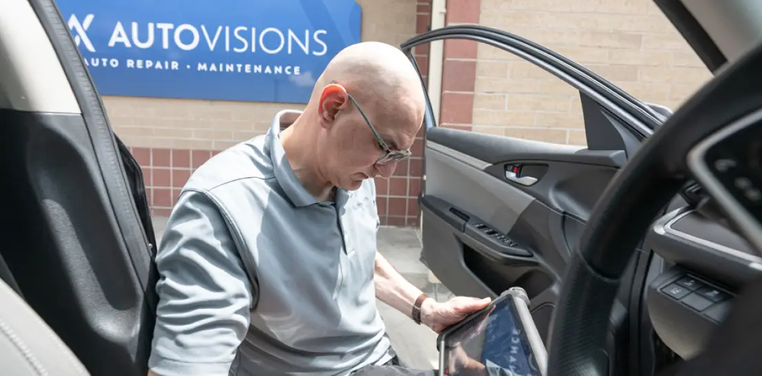 Vehicle Diagnostics in Englewood, CO by Autovisions. Image of Nathan Bryant using an advanced diagnostic scanner inside a vehicle, highlighting the shop’s focus on accurate troubleshooting, electrical testing, and efficient vehicle repair solutions.
